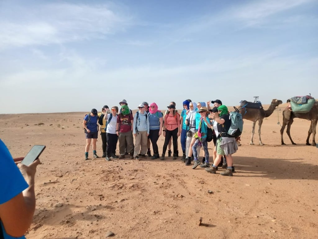 Travelers in the Moroccan desert with camels on an El Farissi Journey experience